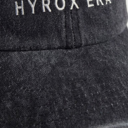 Close-up of black washed cap fabric and off-white embroidery detail