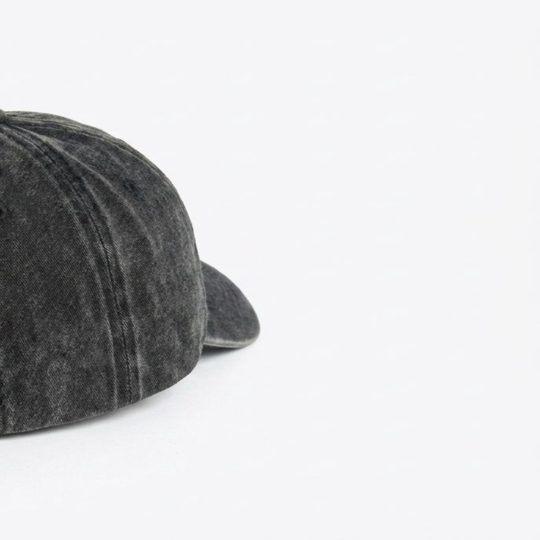 Close-up of black washed cap fabric and off-white embroidery detail