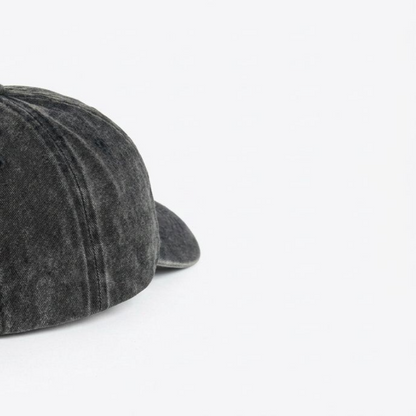 Close-up of black washed cap fabric and off-white embroidery detail
