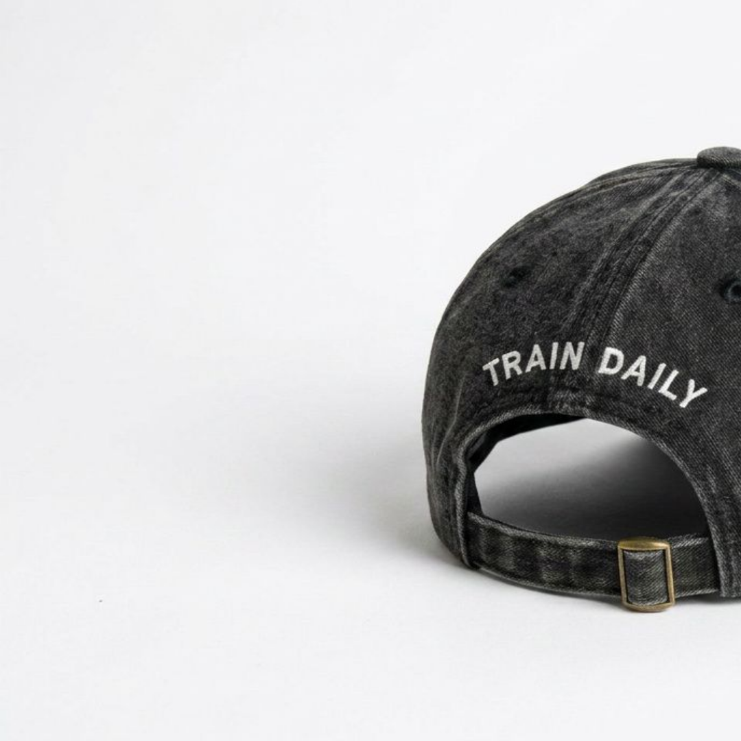 Close-up of black washed cap fabric and off-white embroidery detail