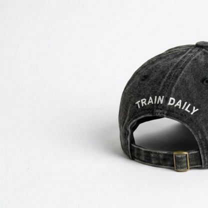 Close-up of black washed cap fabric and off-white embroidery detail