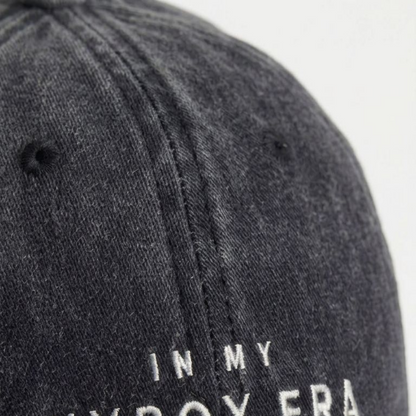 Close-up of black washed cap fabric and off-white embroidery detail